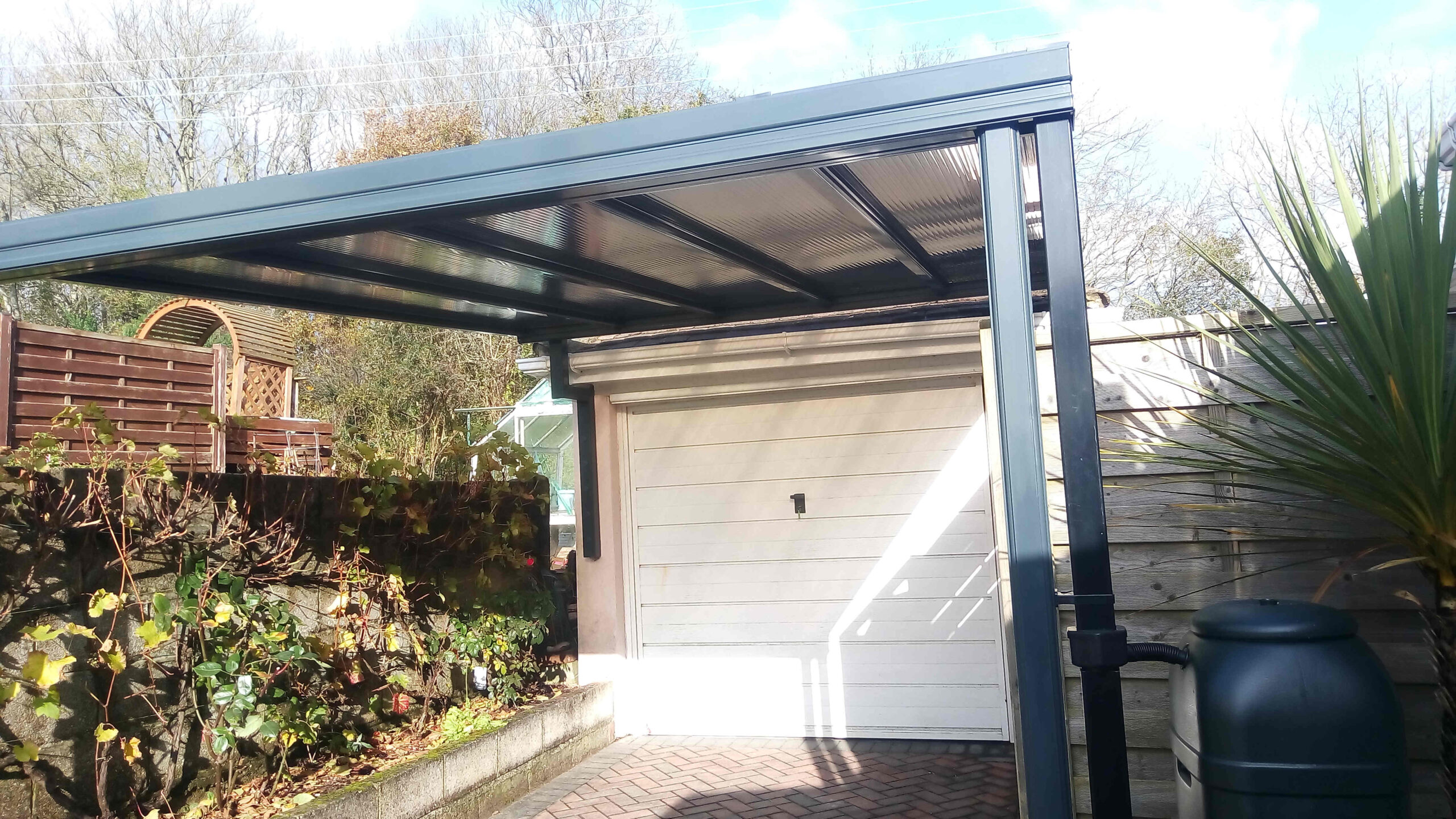 Simplicity 16 carport featuring bronze 16mm polycarbonate roofing and an anthracite grey aluminium frame (RAL7016) in Paignton, Devon