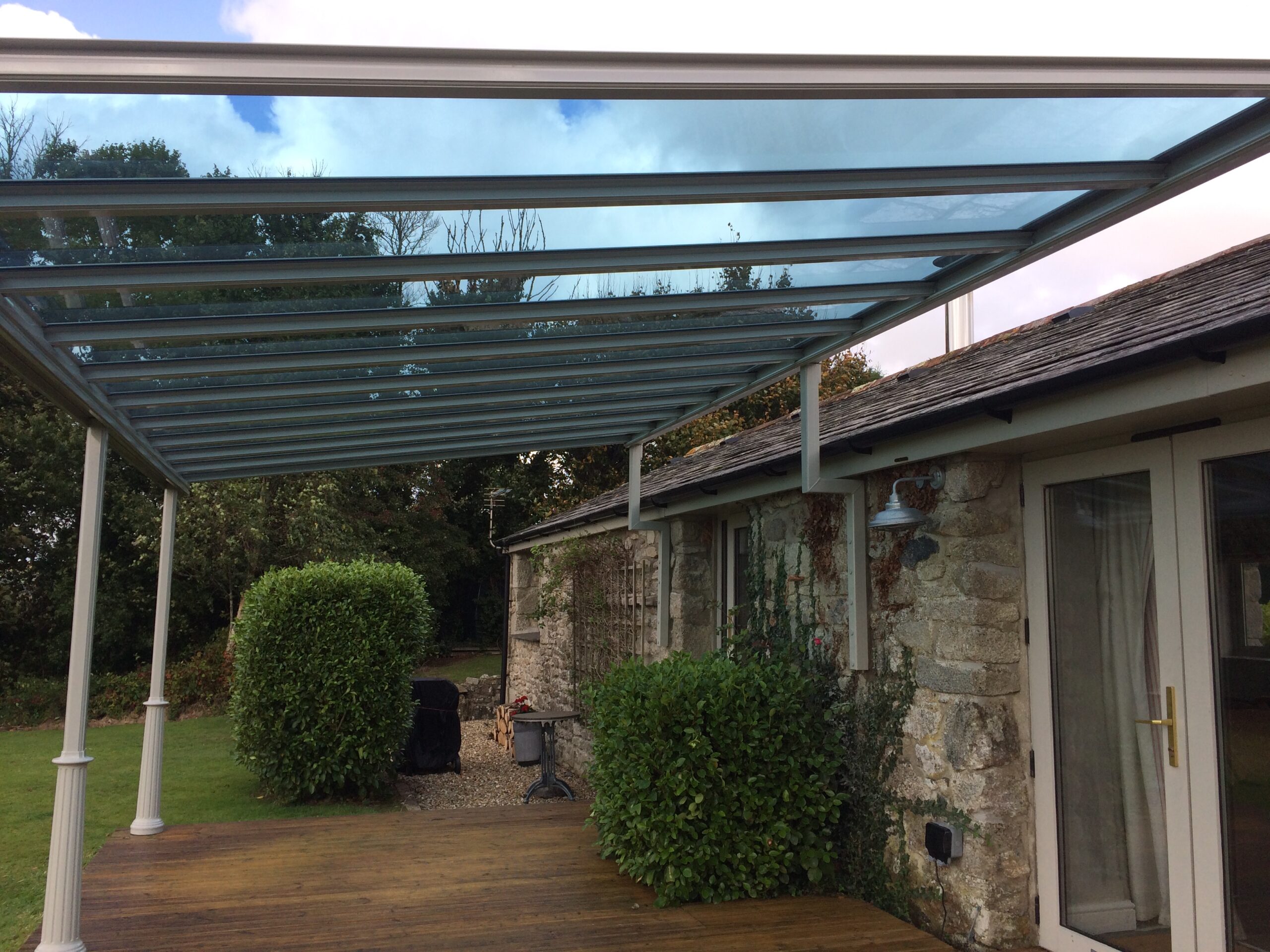 Veranda canopy with glass roof and powder coated in silk grey RAL7044 located in Newquay, Cornwall, provided by All Weather Canopies South West Limited.