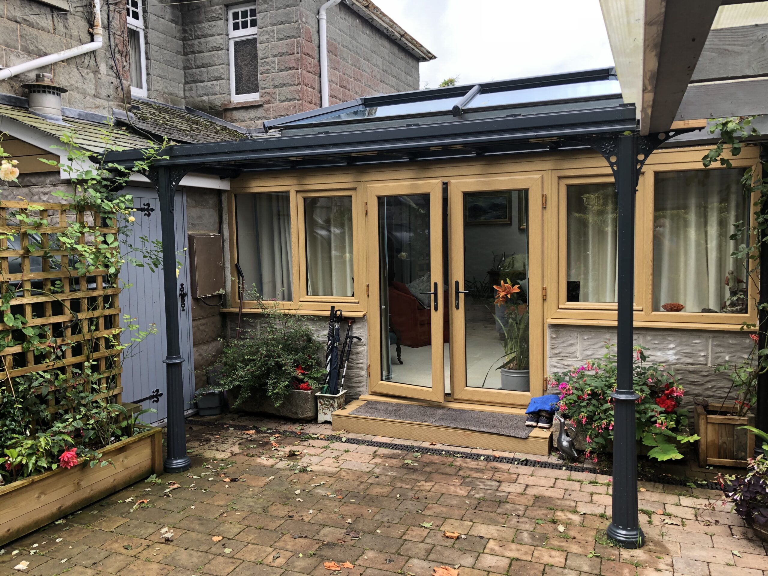Veranda canopy with a glass roof in anthracite grey, featuring traditional Victorian design elements.