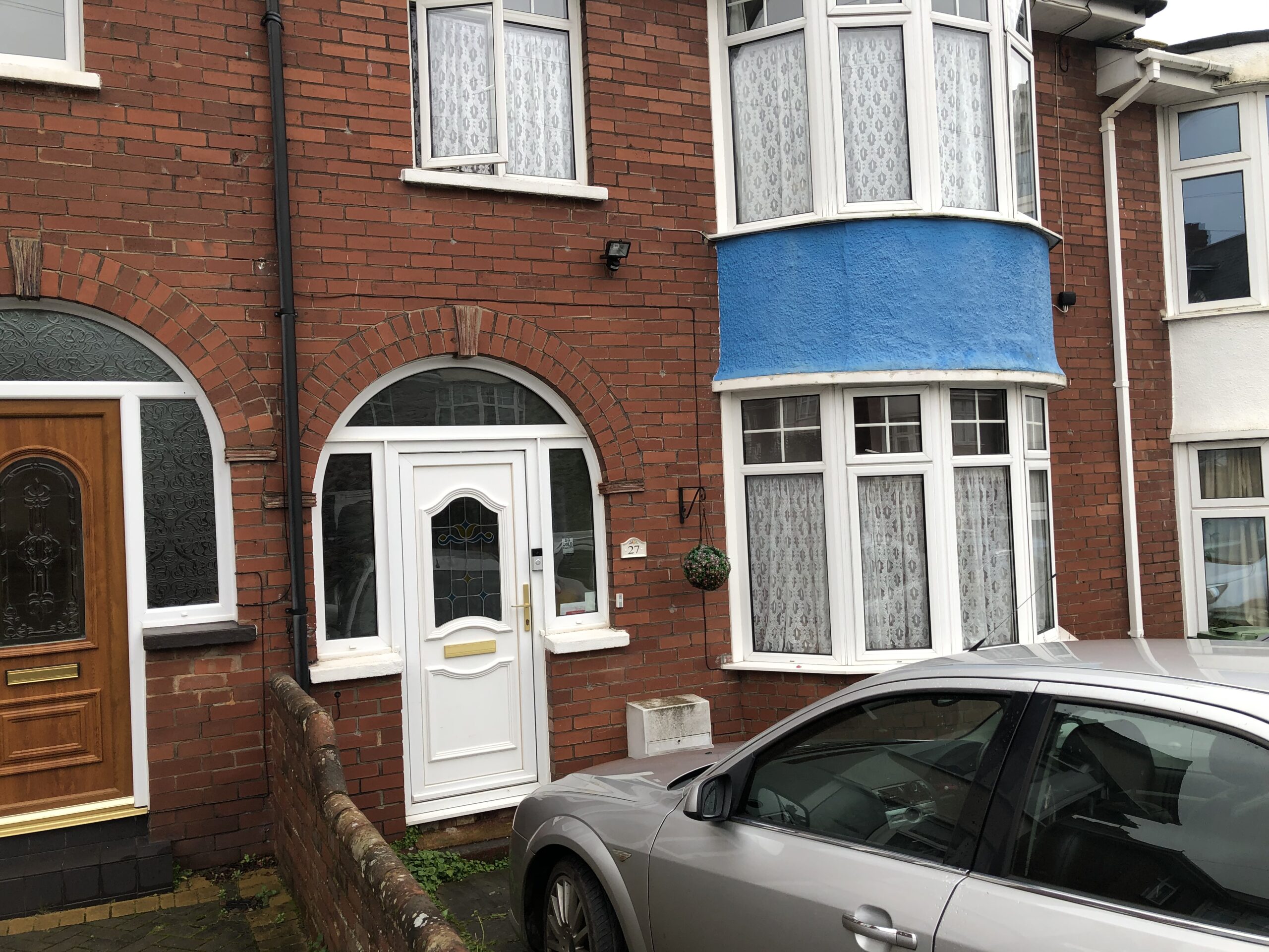 Residential property featuring a brick exterior and a blue bay window on the front facade.