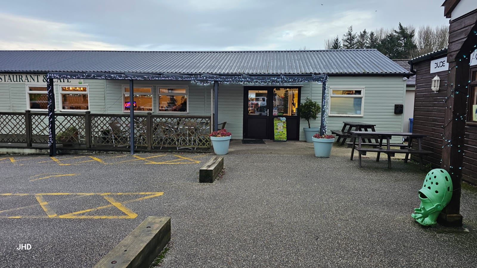 Entrance of Goonhavern Garden Centre with outdoor seating and decorative lights.