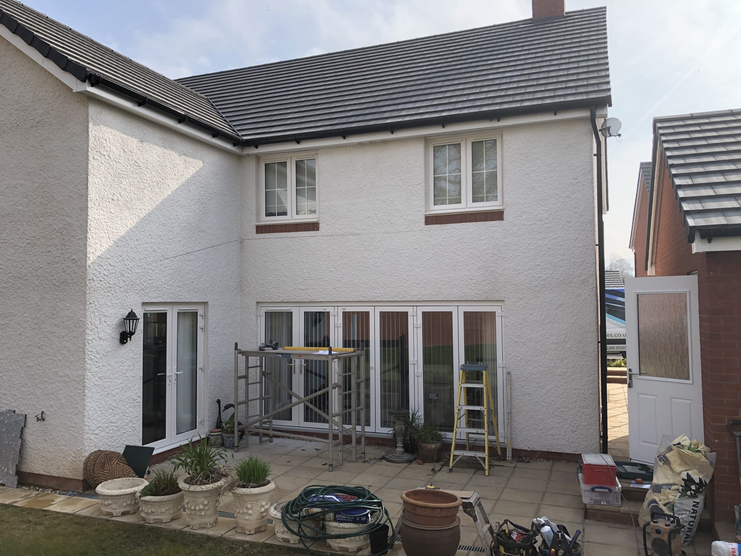 Two-storey residential property undergoing renovation with scaffolding and tools visible.